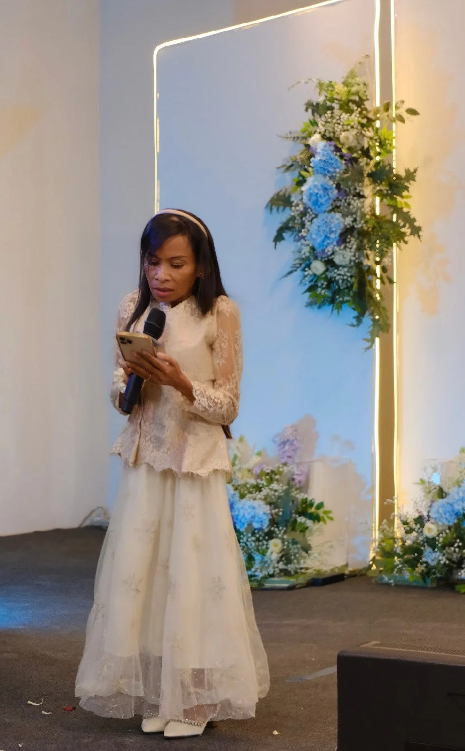 Naleng Real speaking with a microphone at a church event